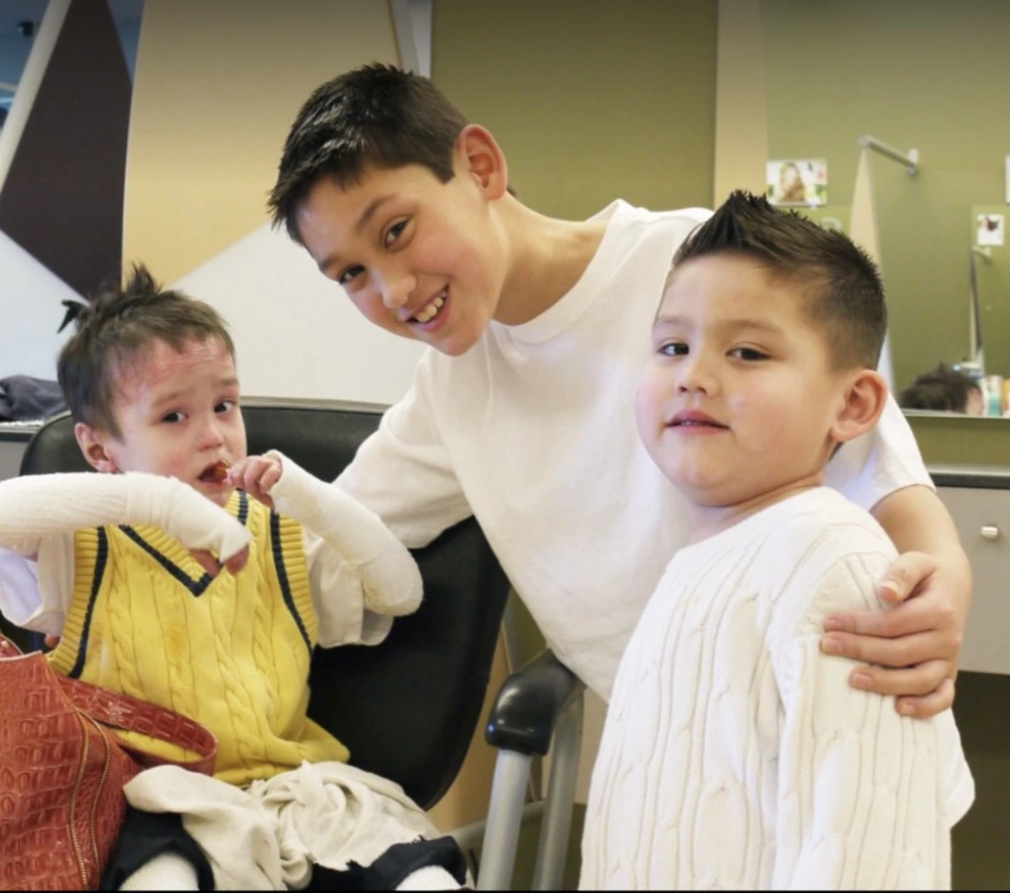 Julian as a child with his brothers, one recovering from a bandaged arm, in a family photo